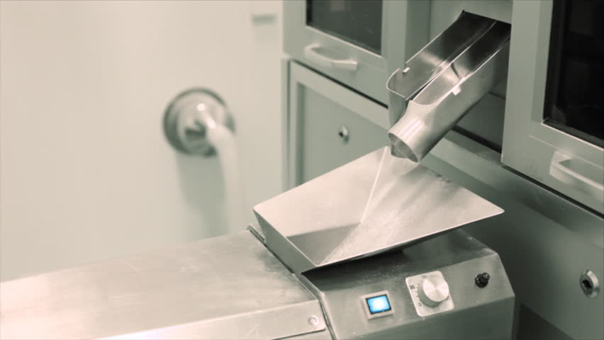 Pills falling out of pill manufacturing machine. Special Light and air conditions in the room.