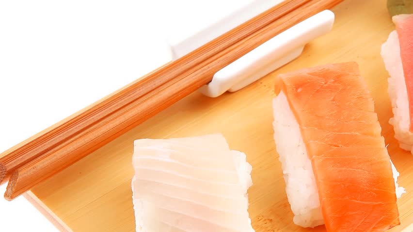Japanese traditional cuisine - Set of Tuna (maguro) Salmon (sake) and Eel (unagi) Nigiri Sushi with Wasabi and chopstick on wooden plate hidef slow motion