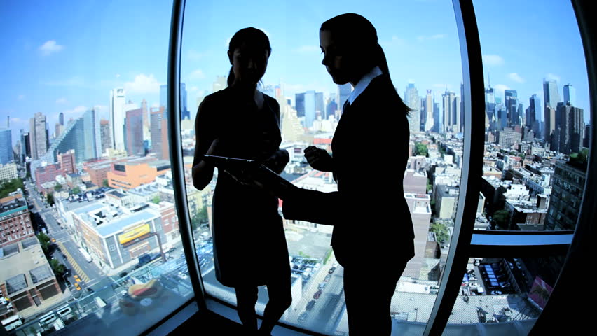 Silhouette successful multi ethnic female business team using touch screen technology in modern city workplace