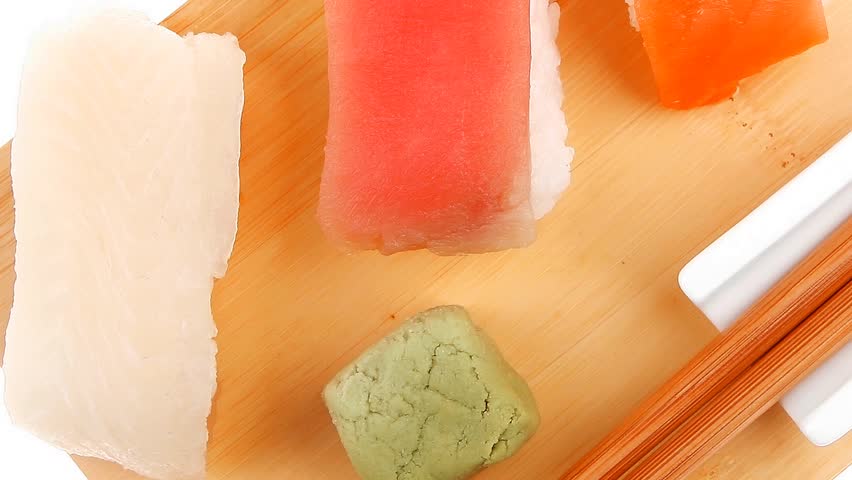Japanese traditional cuisine - Different Types of Nigiri Sushi : Tuna (maguro) Salmon (sake) and Eel (unagi) with Wasabi and chopstick on wooden plate hidef intro slow motion