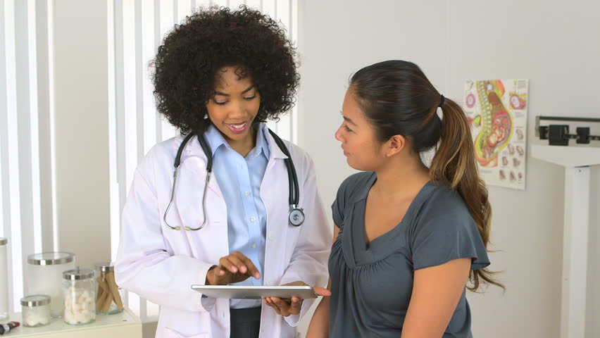 multi-racial doctor patient discuss matters on a tablet