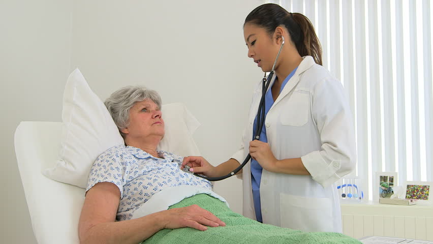Female multiracial doctor listening to her patient's heartbeat