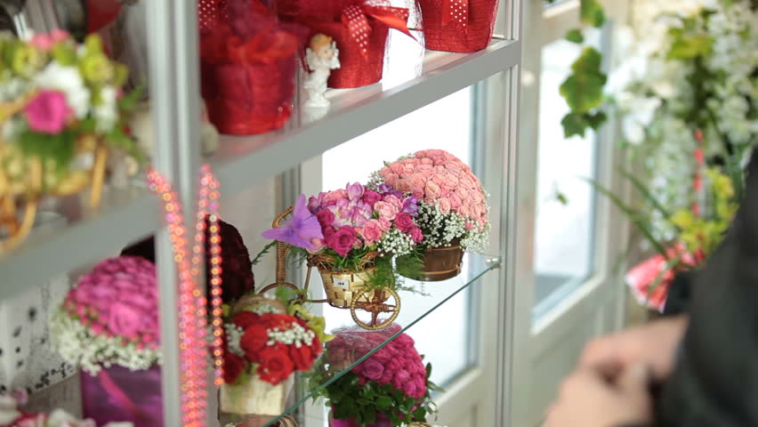 The young man choosing flower arrangement in florist shop