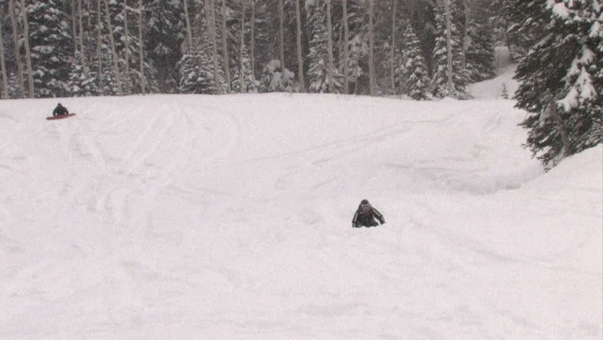 FAIRFIELD UT - FEB 14: Snowboarder in blizzard Feb 14, 2008 in Fairview, Utah. Snowboard ski riders in winter mountains of Utah. Forest area. Deep powder. One crashes off a small jump.