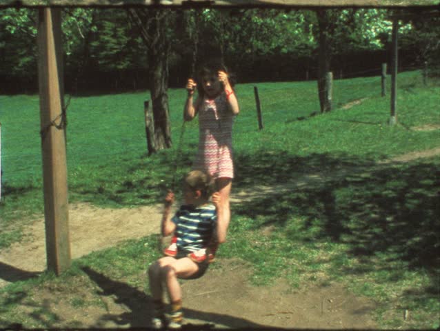 Vintage 8 mm film: Children on playground swing, 1970s