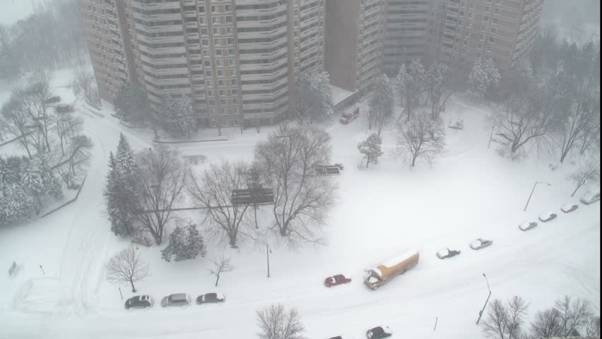 School Bus in Snow Storm trying to drive into to the street from its parked location