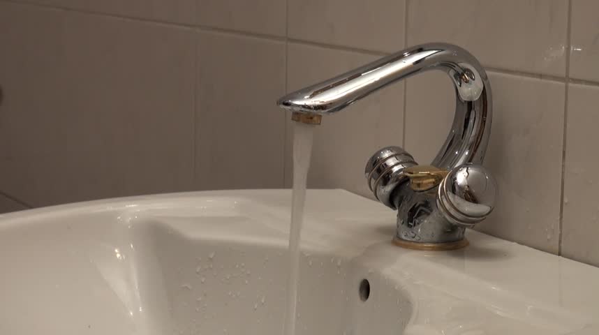 Dirty male hands being washed in bathroom