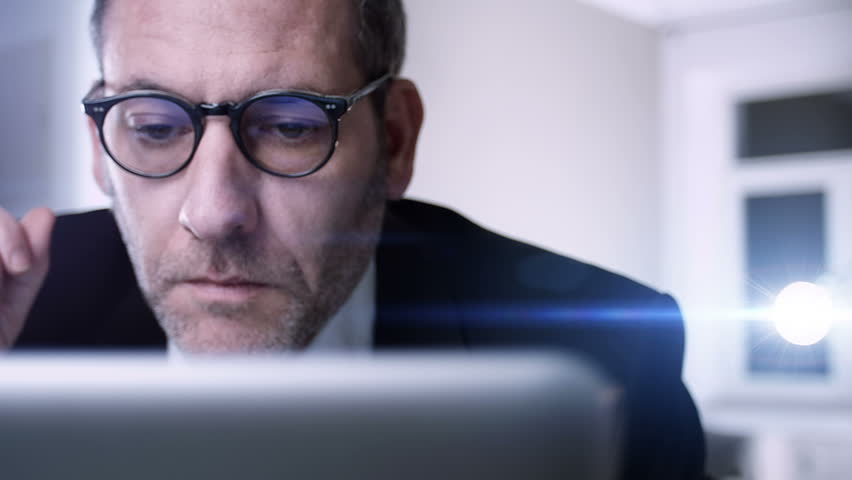 businessman gets very bad news on his computer screen
