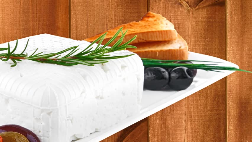 feta cube and olive over white plate with bread