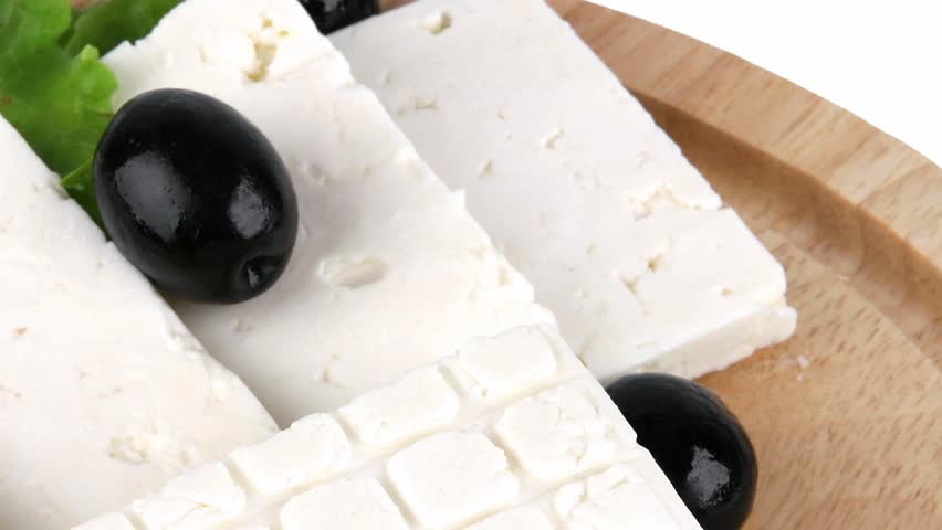feta cheese with olives on wooden plate