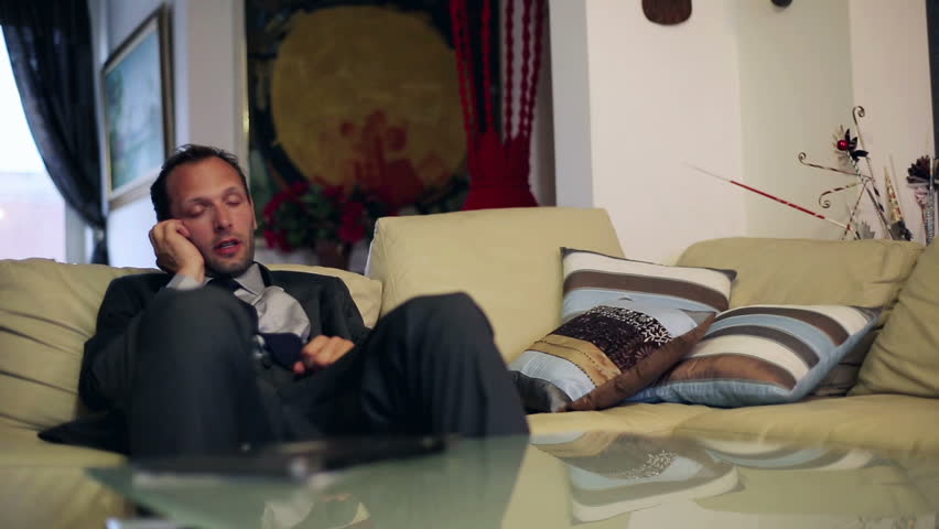 Businessman gets coffee from wife during a telephone call in livingroom
