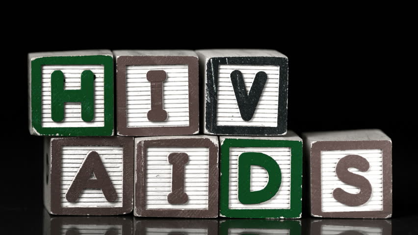 Condom falling on blocks spelling Aids and Hiv in slow motion