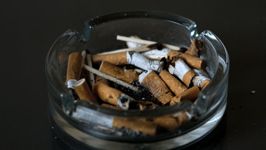 Cigarette falling into ashtray in slow motion