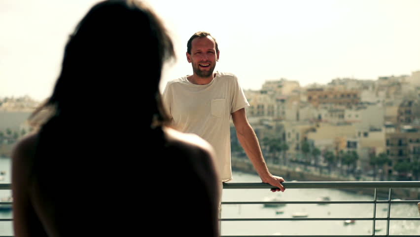 Happy couple standing on the terrace and looking at marina, slow motion shot at 120fps
