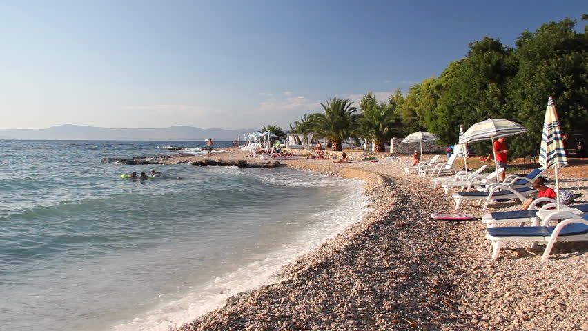 People on the beach, sunbathe and enjoy on vacation. Summertime at Adriatic Sea on the island Brac in Croatia