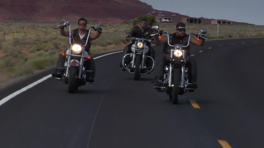 Three bikers on a winding desert highway