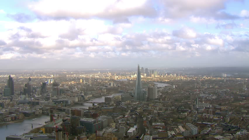 Stunning panoramic aerial view and cloudscape, flying over the city of London and the River Thames on a bright day