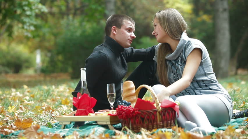 Young loving couple having a picnic in autumn park