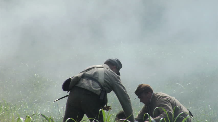 GEORGIA - OCTOBER 2008 - large-scale, epic Civil War anniversary reenactment -- in the middle of battle.   Line of Confederate infantry fires at will in line of battle as men try to rescue wounded