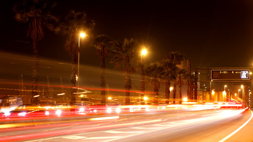 rush of night time traffic on motorway in timelapse scene, barcelona, spain