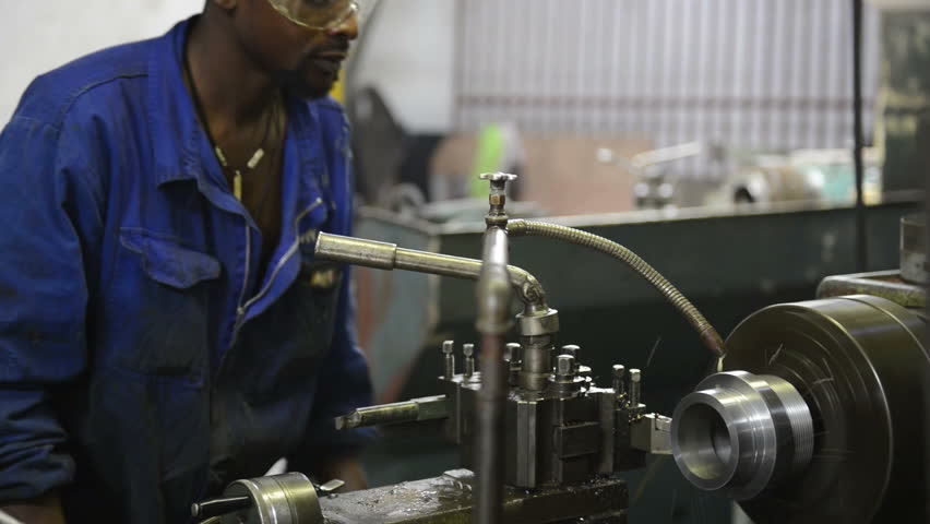 An industrial service repairmen labouring in workshop, selective focus, working on industry machine 