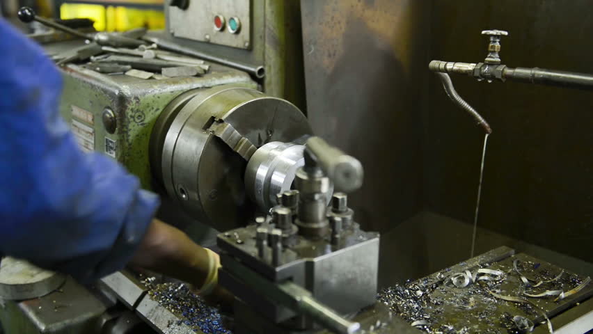 An industrial service repairmen labouring in workshop, selective focus, working on industry machine 