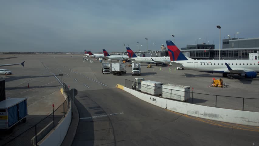 Minneapolis - Circa 2012: Time-lapse of Jet airliners and service trucks arriving and departing outside the terminal