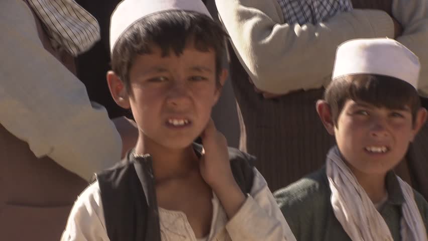 Cakolc, Afghanistan - November 9, 2010: Students and teachers in the yard in front of a Madrasa (Religious School) in remote north-east of Afghanistan.