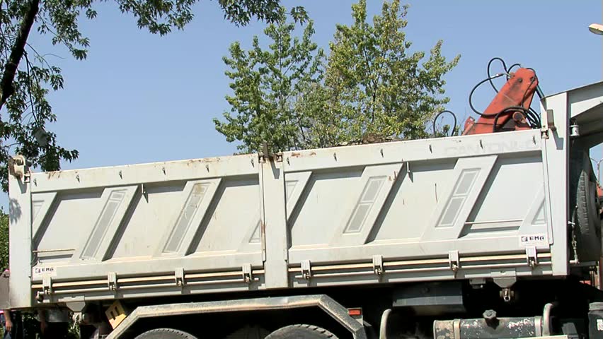 Excavator loading truck with ground, road works