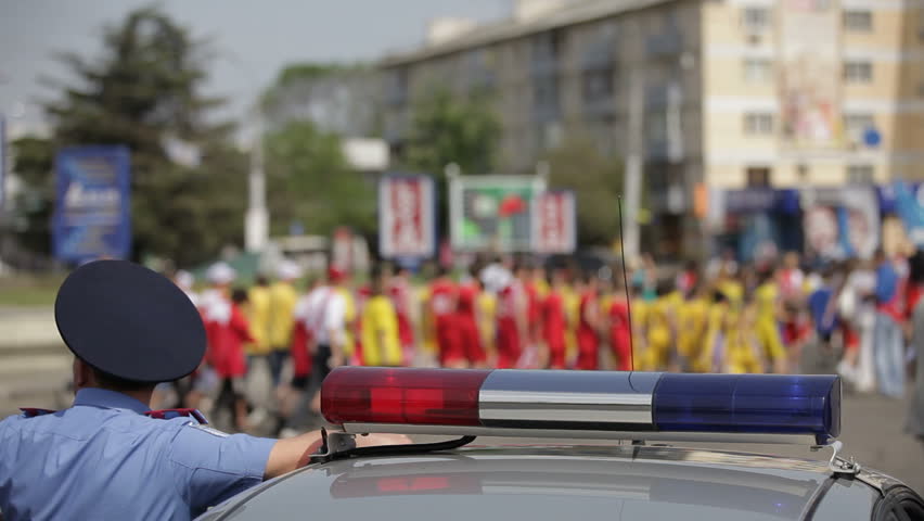Police car lights flashing,with crowd out of focus in background