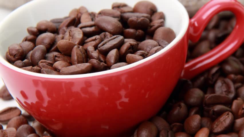  white and red ceramic cup heart symbol full of coffee beans
