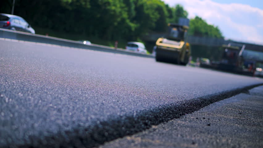 Road roller compacting the asphalt