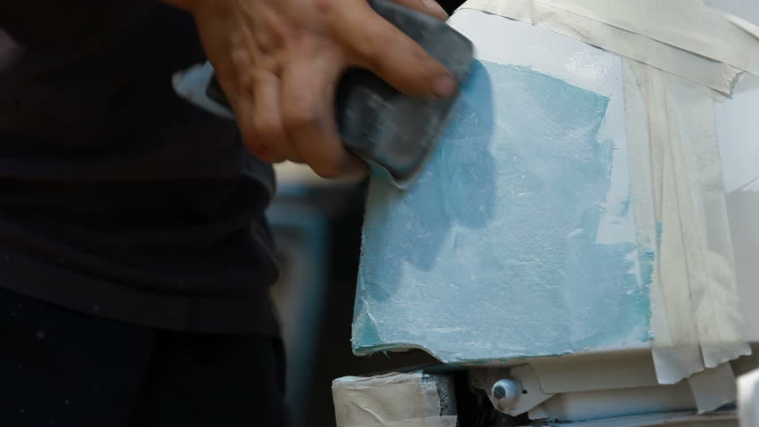 Smearing putty on damaged surface, car repair