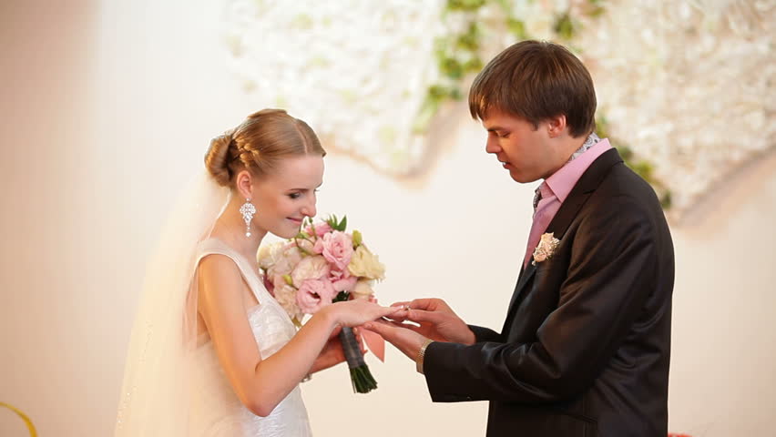 Groom and bride are exchanging wedding rings.