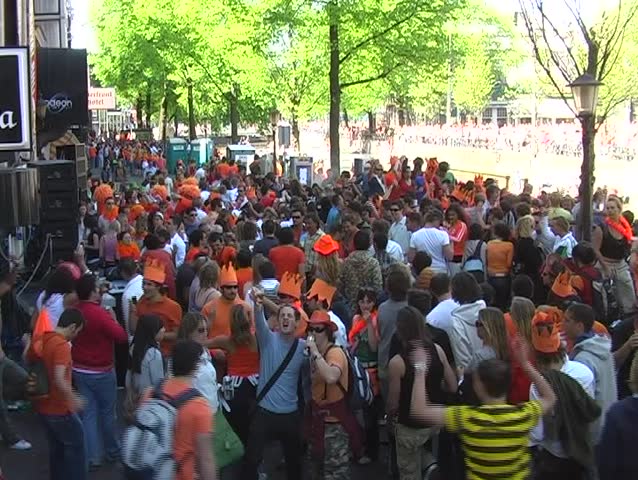 Crowd dancing in the streets during queensday in Amsterdam the Netherlands