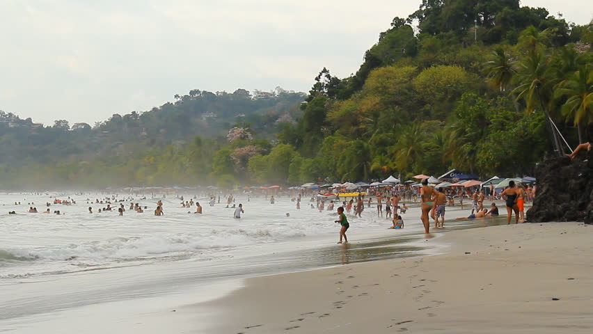 COSTA RICA - MAR 2013: Mostly local "Ticos" gathered on a beach just outside Manuel Antonio National Park in Quepos, Costa Rica in March, 2013.