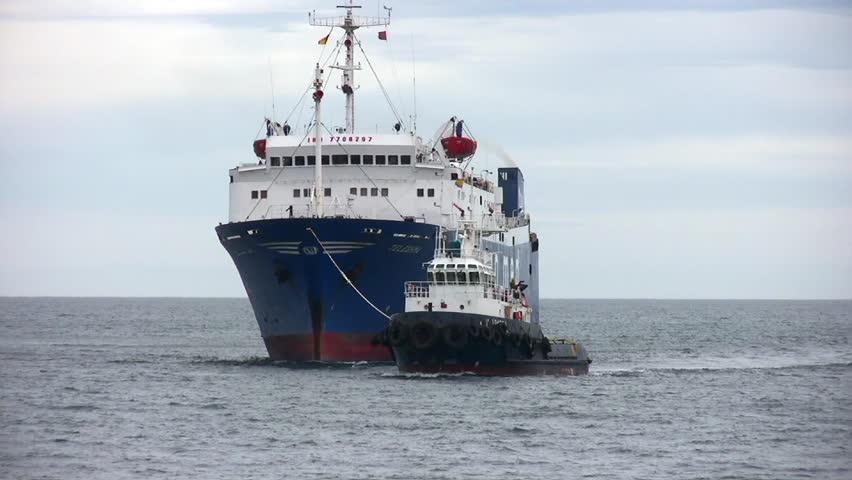 ALICANTE, SPAIN â APRIL 04: The tug "J. TORRES" is working with the general cargo vessel âTELEGHMAâ for entering in the port of Alicante; Spain; on april 04, 2013 in Alicante.