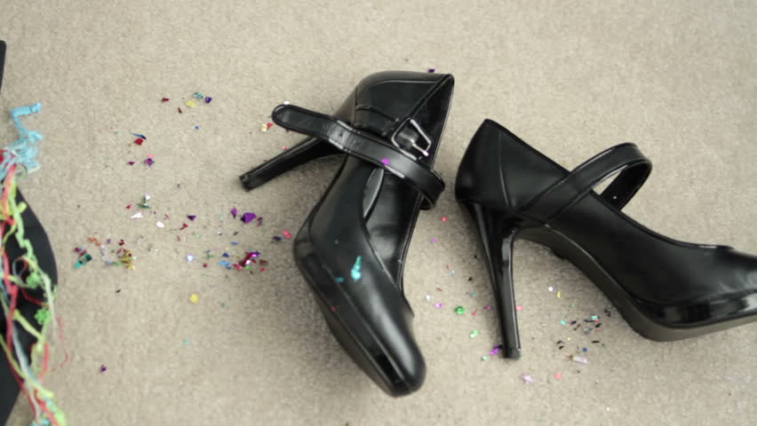 Panning across clothes shed after a big night reveals high heeled shoes and a discarded tuxedo along with glitter and streamers.