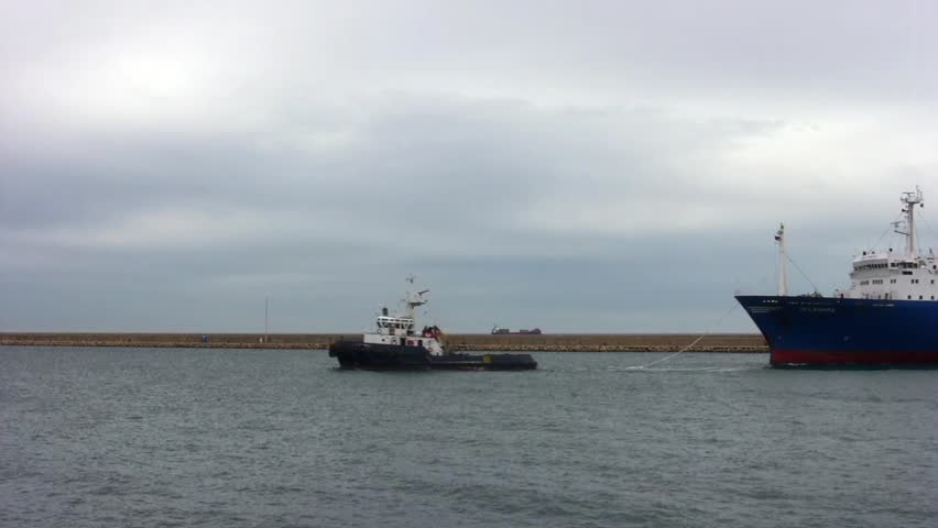 ALICANTE, SPAIN â APRIL 04: The tug "J. TORRES" is working with the general cargo vessel âTELEGHMAâ for entering in the port of Alicante; Spain; on april 04, 2013 in Alicante.