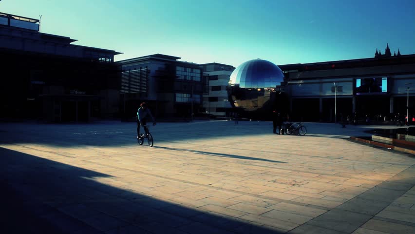BRISTOL - April 6: Cyclist Passes Through Millennium Square & Does Trick on BMX Bike on April 6, 2013 in Bristol, England.