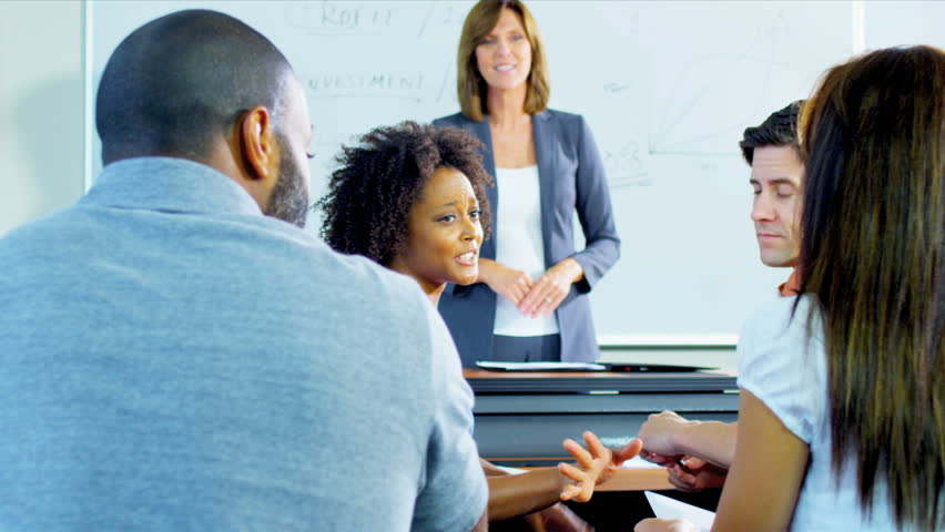 Group multi ethnic adults attending work retraining in modern classroom with female instructor shot on RED EPIC
