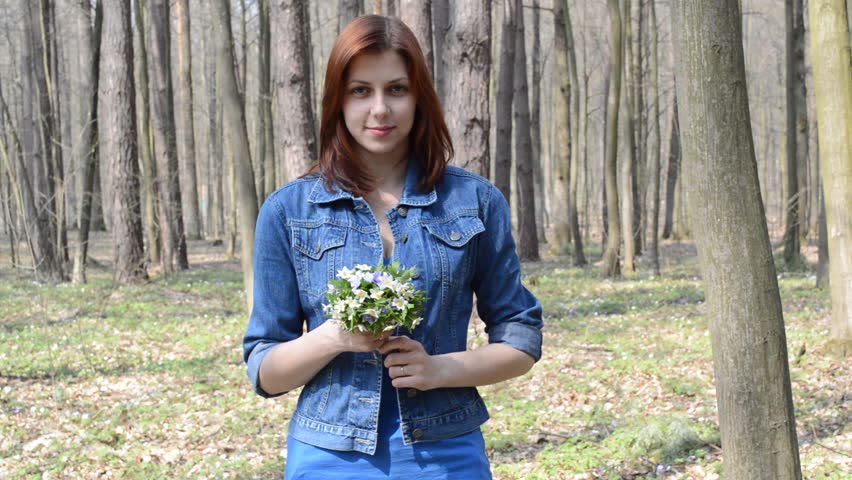 beautiful smiling girl smelling wildflowers