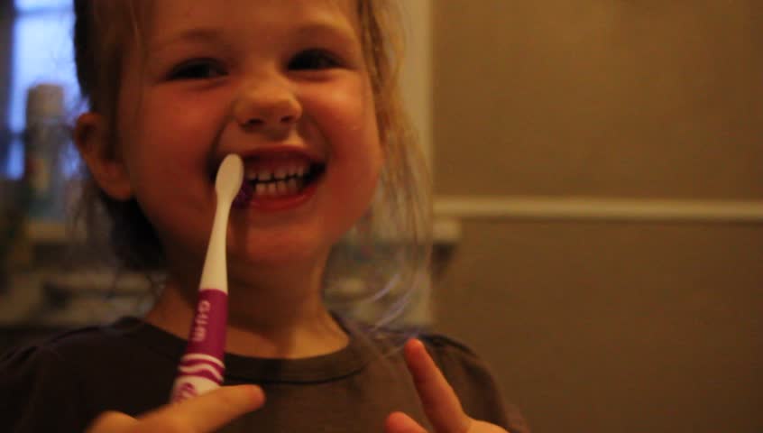 Small child brushes teen with a big smile on her face, fun short video of normal everyday life
