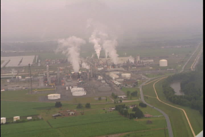 CONVENT, LOUISIANA - CIRCA SEPTEMBER 1999: Aerial shot of oil tanks and smoke spewing from oil refineries and chemical plants in Convent, LA.