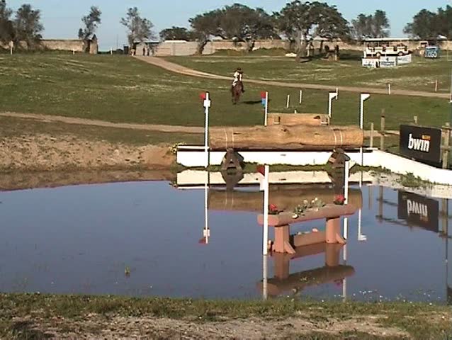 Horsewoman jumping the fence for the water