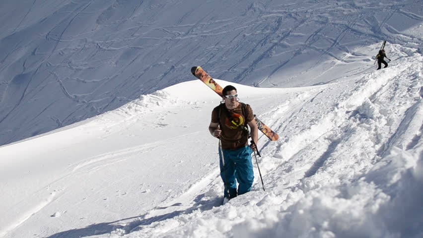 free ride skier hiking up snow slope in winter