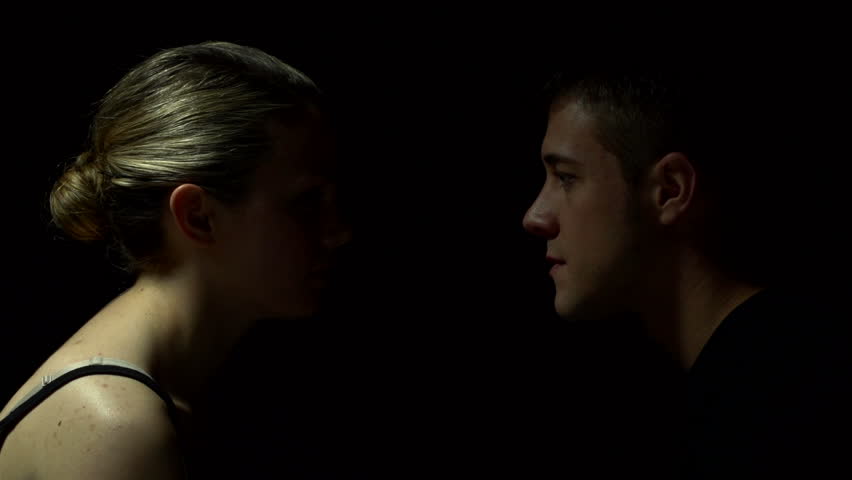 Studio shoot of man and woman facing each other in color. Experimental lighting. 