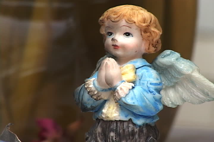 NEW YORK CITY - SEPTEMBER 29, 2001: Little ceramic praying angel figure left at 9/11 memorial outiside Engine 23 fire station.