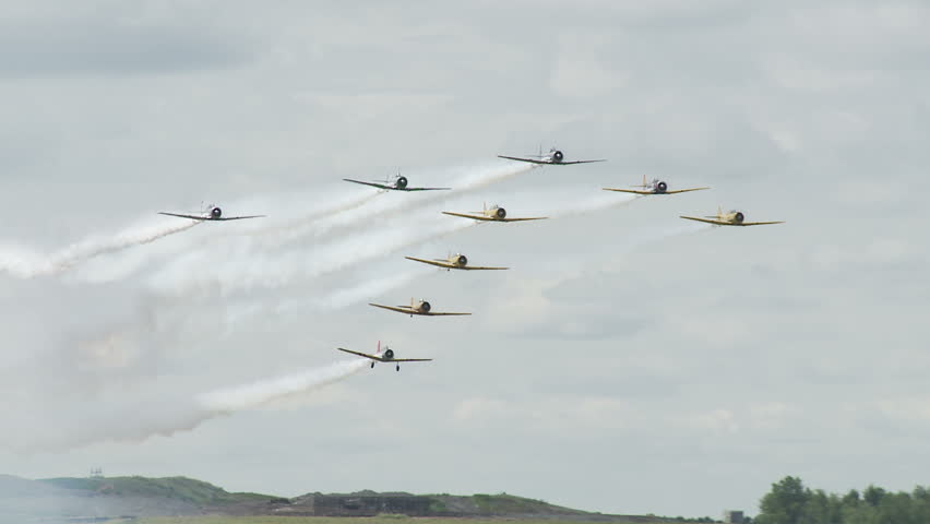 USAF T-6 Texans flying in a T-formation with Canadian Air Force Harvards, small training aircraft from WWII.