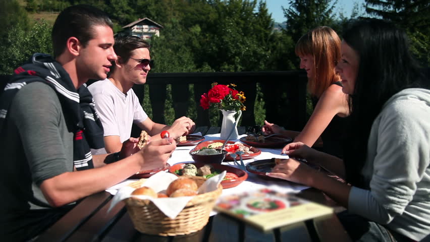 Two couples eating cold cuts for lunch in nature lunch